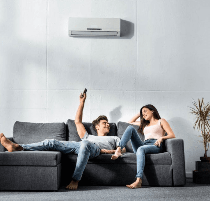 Couple détendu dans un salon avec climatisation murale en fonctionnement